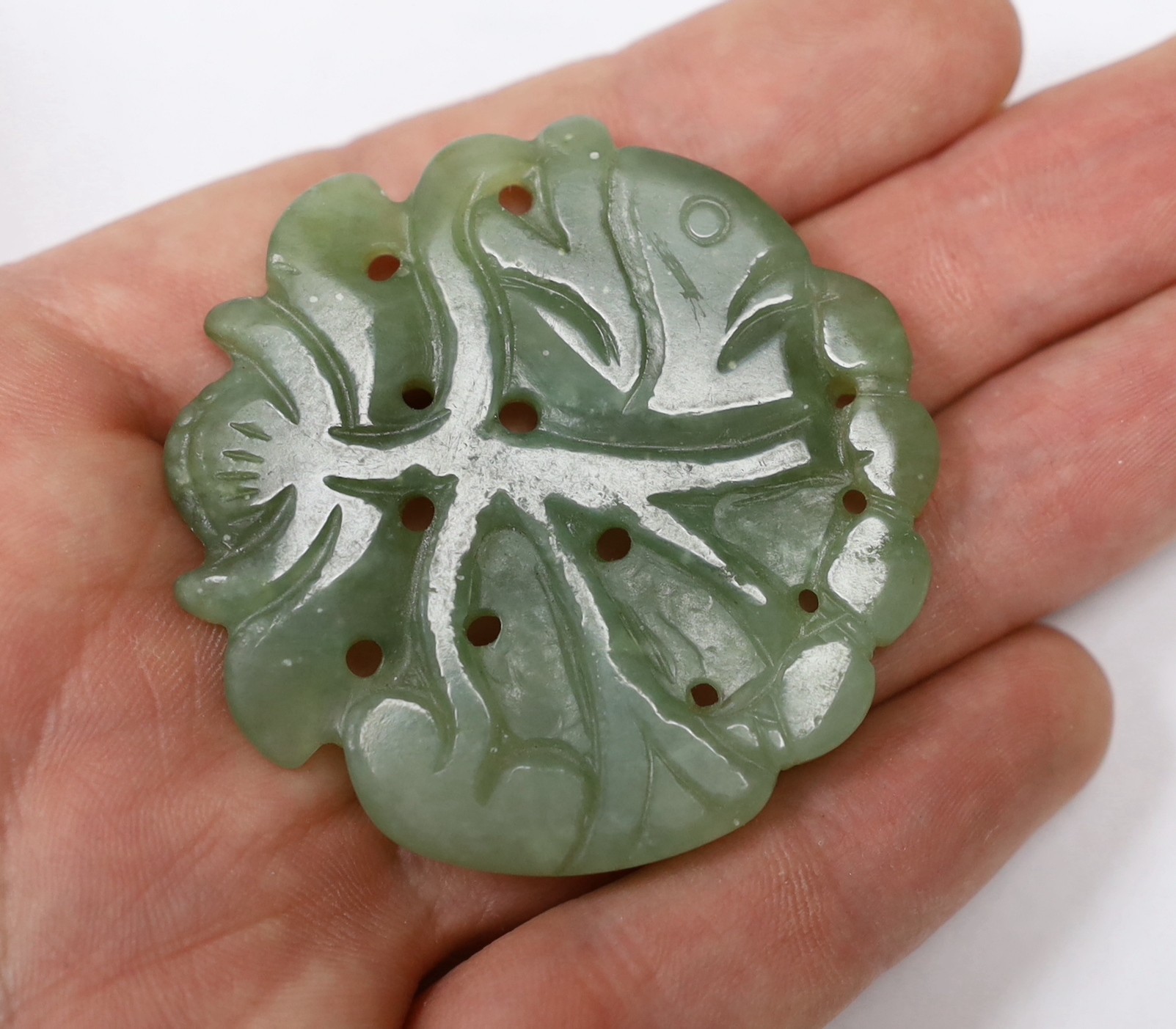 A Chinese carved green hardstone pendant shaped as a fish, 5cm